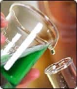 green liquid in beaker being added to test tube