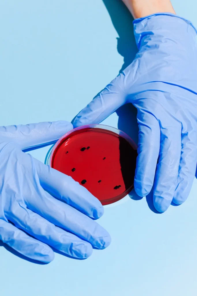 Hands in blue gloves framing PEG hydrogel medical application.